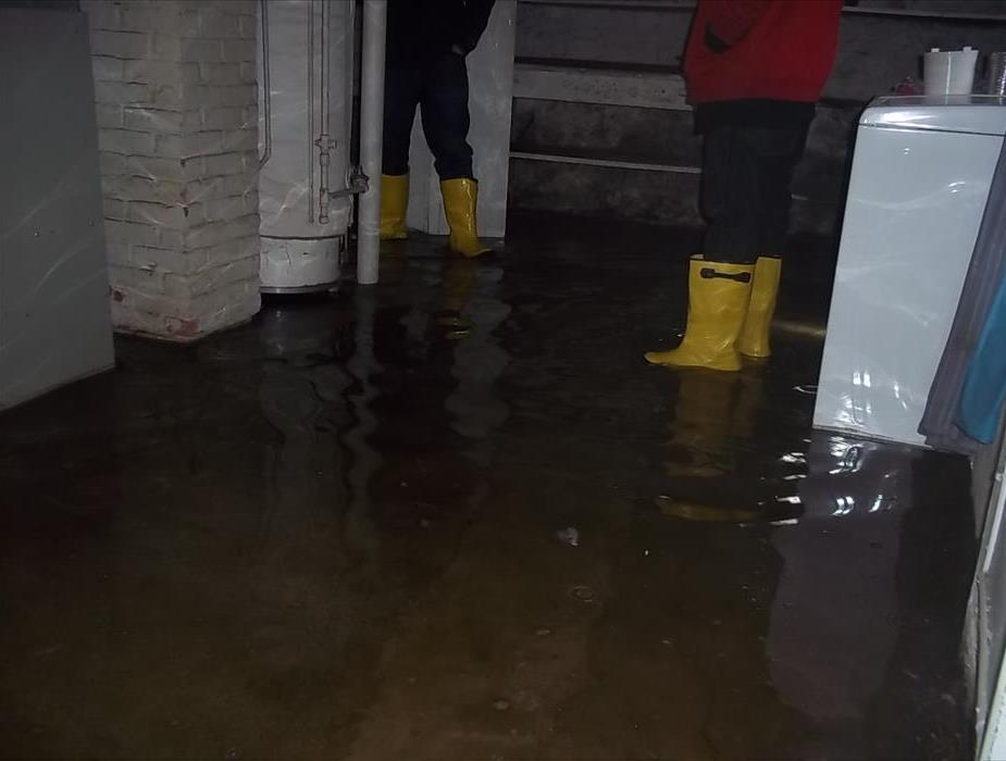 two technicians standing in a flooded basement