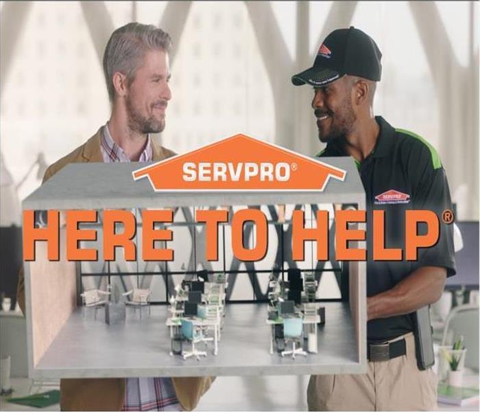 SERVPRO Logo with text, Here to Help, over image of client and technician holding a model of an office space