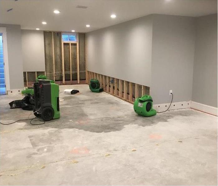 Basement with flood cuts, flooring removed, and air movers installed